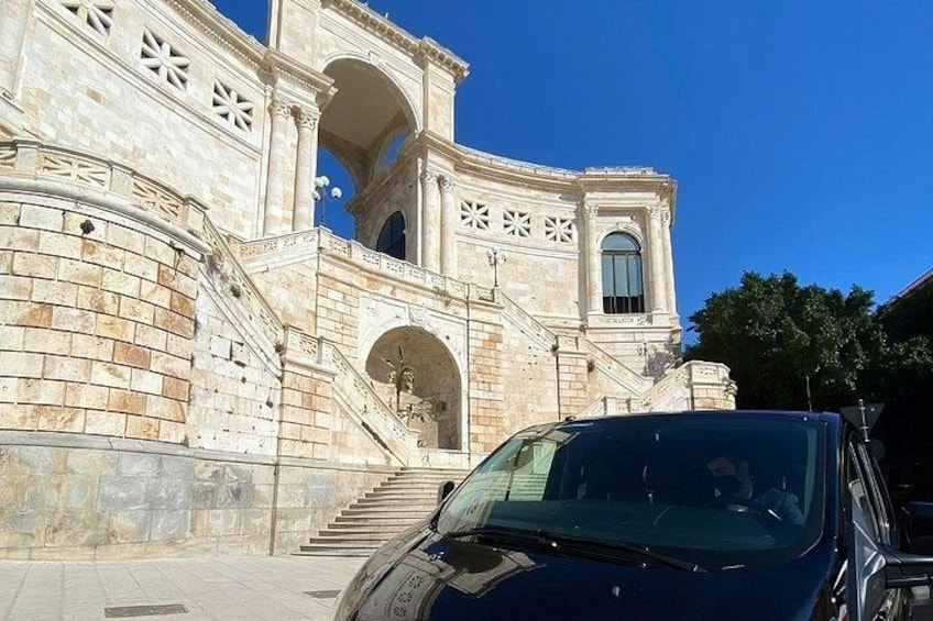 A stone building with a staircase leading to an arched entrance. 4