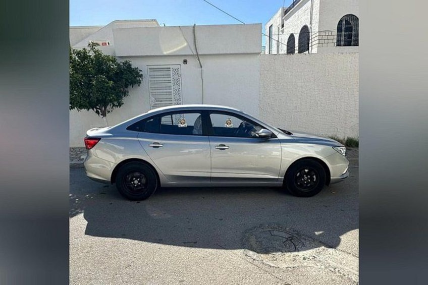 A white sedan parked on a street. 2
