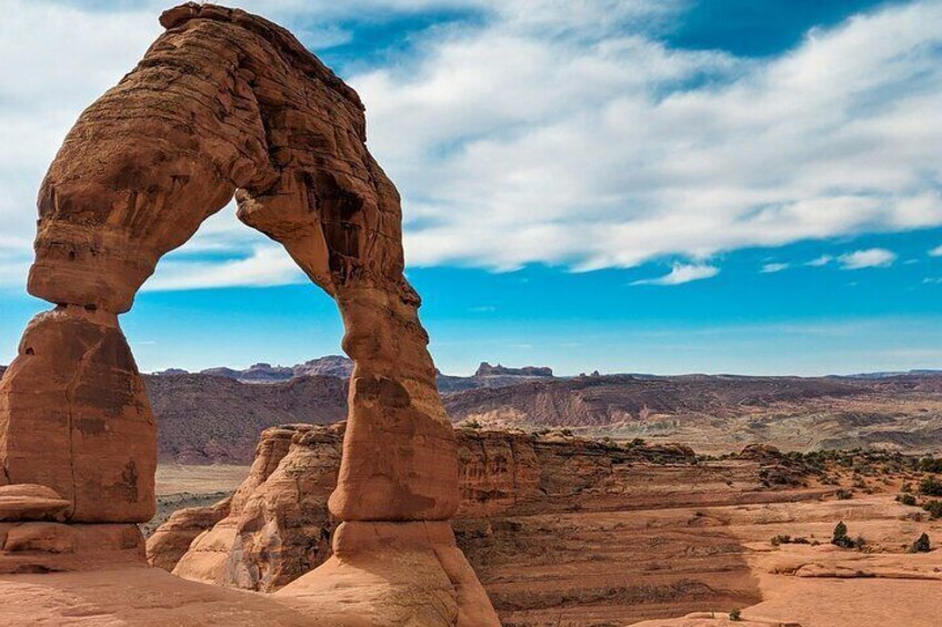 A natural rock arch formation in a desert landscape. 1
