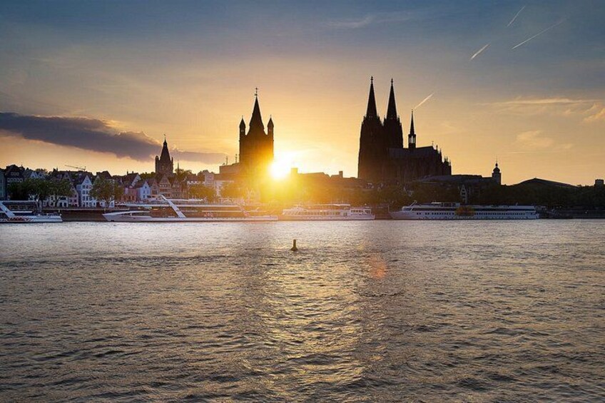 A river with a boat, a bridge, and a cathedral during sunset. 1