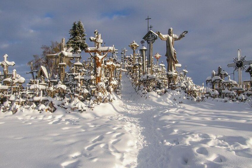 A snow-covered cemetery with numerous statues and crosses. 5