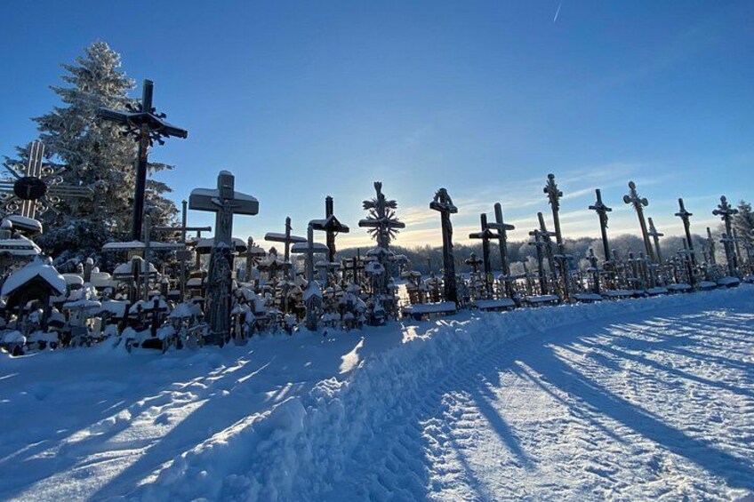 A snow-covered cemetery with numerous crosses and tombstones. 3