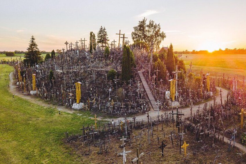 A cemetery with numerous crosses and tombstones, surrounded by trees and a grassy area. 1