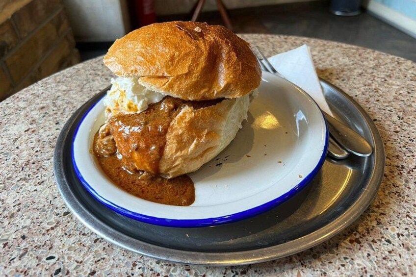 A sandwich on a plate with a fork and knife. 3