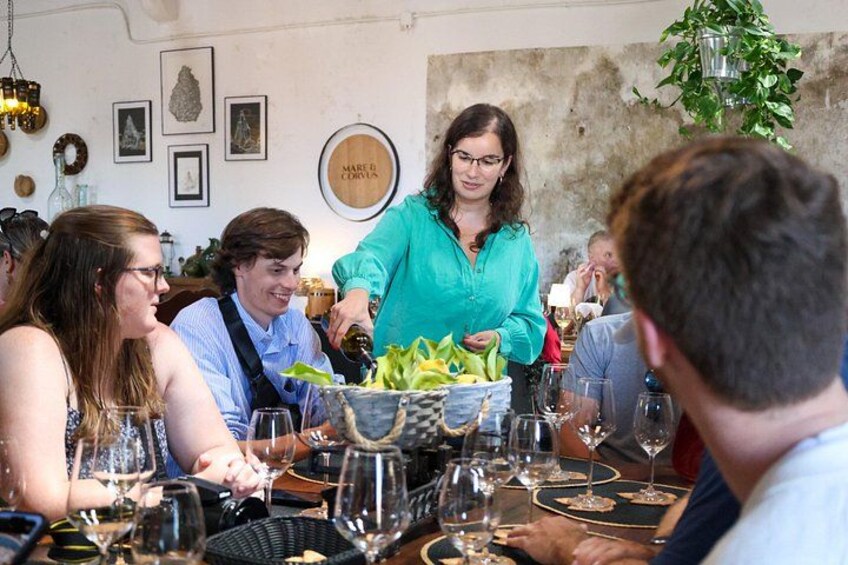 Un grupo de personas cenando en un restaurante con una decoración rústica, que incluye una pared de piedra y cuadros enmarcados. 4