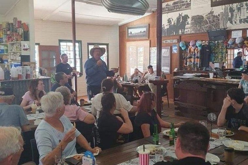 Un restaurant où des clients sont assis à des tables, un barman se tient derrière le comptoir et une personne est debout à l’entrée. 5