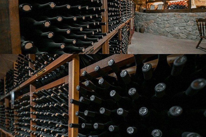 Una bodega con hileras de botellas de vino en estanterías de madera. 2