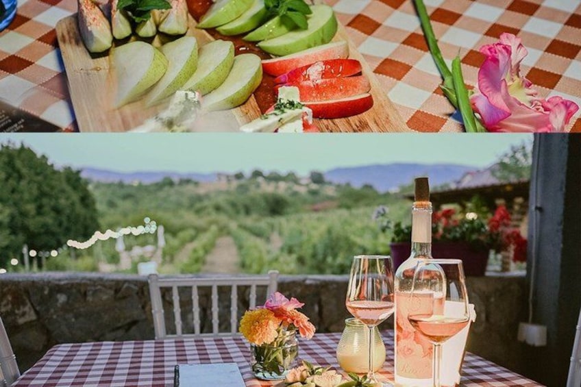 Een tafel met fruit, een fles en glazen, voor een wijngaard. 2