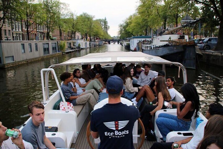 Un grupo de personas en un bote navegando por un canal, con edificios a ambos lados. 3
