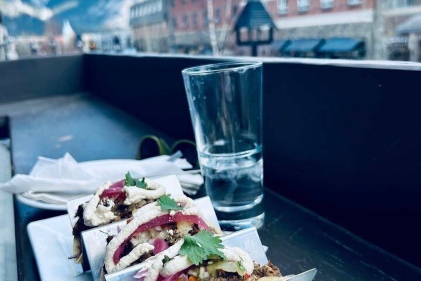 En sandwich på et bord med et glas vand ved siden af. 2