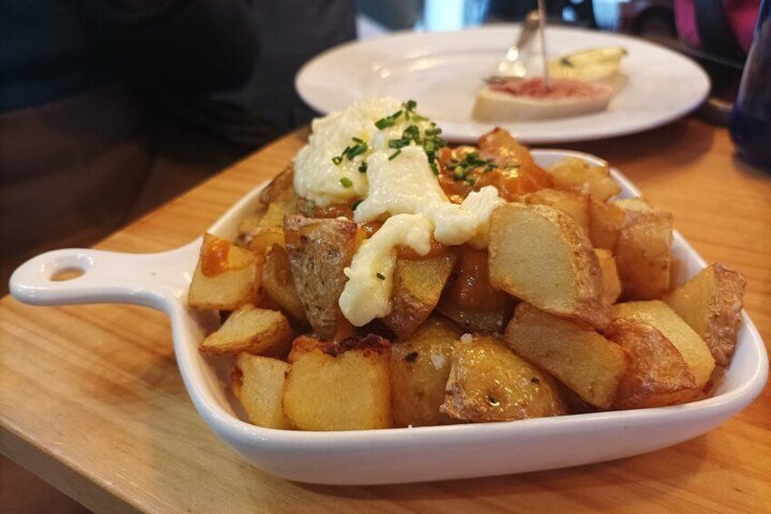 Un plato de patatas asadas coronado con salsa cremosa y adornado con hierbas. 2