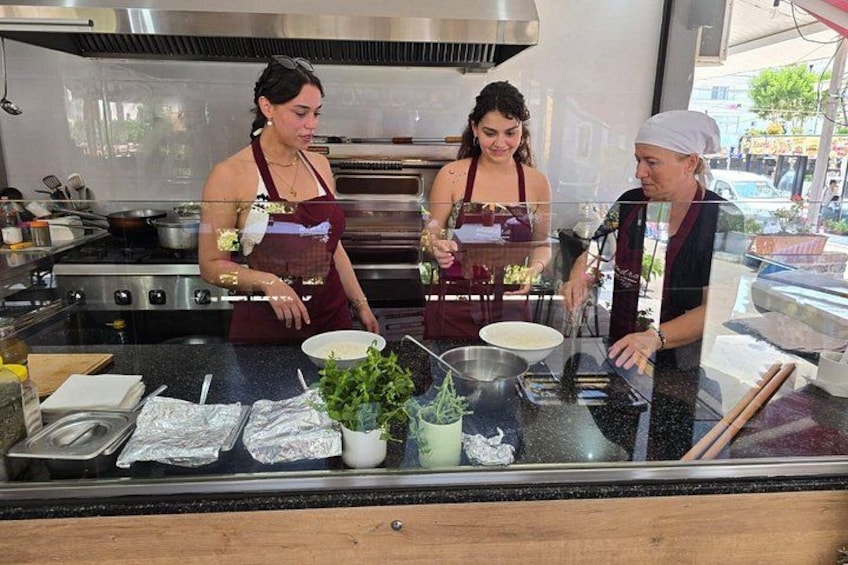 Three people in a kitchen preparing food. 5