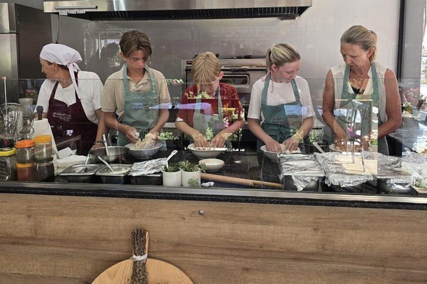 Four people preparing food in a kitchen. 2