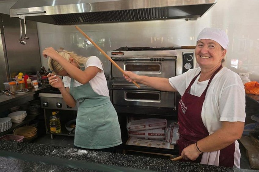 Two people in a kitchen, one using a wooden spoon and the other holding a ladle. 3
