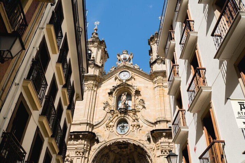Un edificio storico con architettura elaborata, una torre dell'orologio e una statua sulla sommità. 2