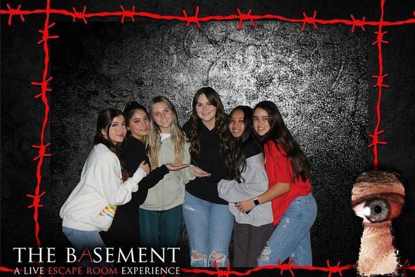 A group of people in a room with a textured wall and a red border. 2