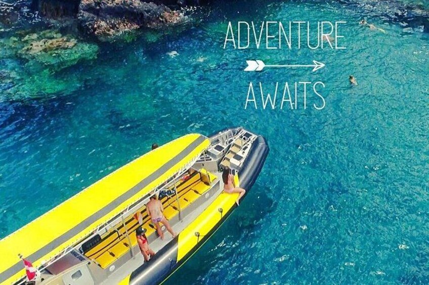 A yellow inflatable boat on clear blue water with the text 'ADVENTURE AWAITS'. 1