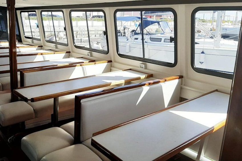 A boat interior with rows of seating and windows. 2