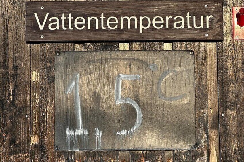 A wooden sign with 'Vattentemperatur' and a metal plaque displaying '15°C'. 4