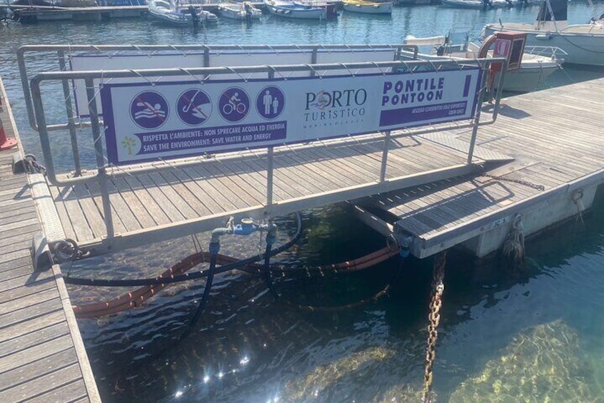A dock with a signboard, a chain, and a boat. 4