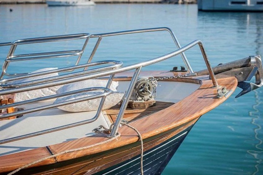 Una barca de madera con barandillas metálicas y una cuerda atada al muelle. 5