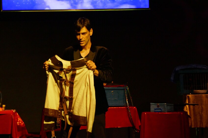 A person holding a white garment with brown details. 5