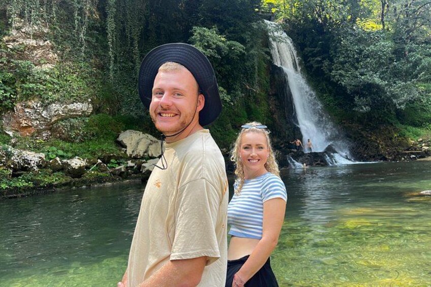 A waterfall, a river, and a person wearing a hat. 2