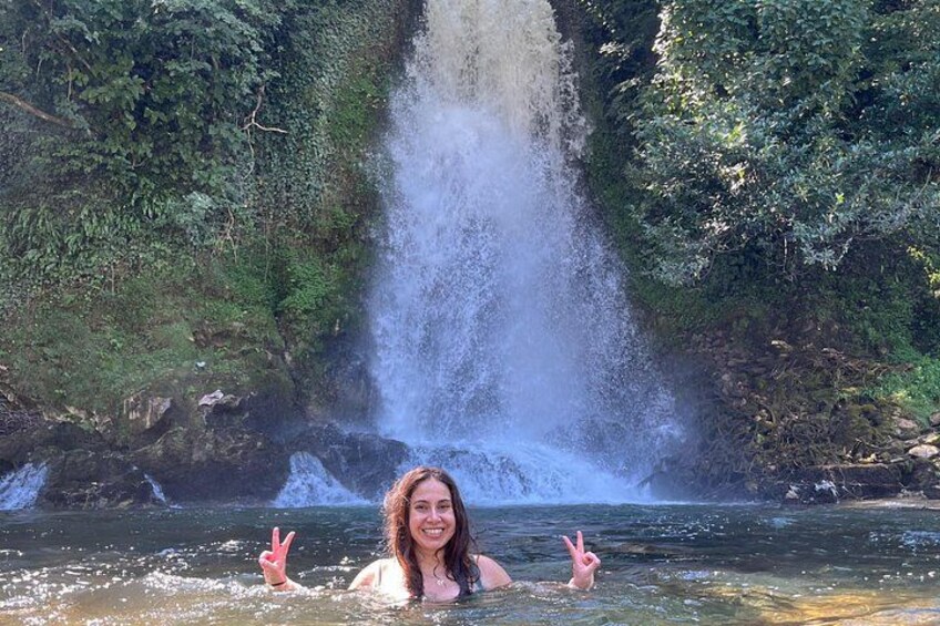 Ein Wasserfall, eine Person die ein Friedenszeichen zeigt, und ein Fluss. 3