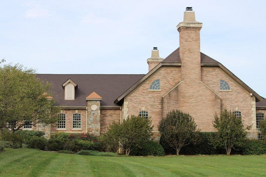 A large brick house with a chimney, surrounded by a well-maintained lawn and trees. 3