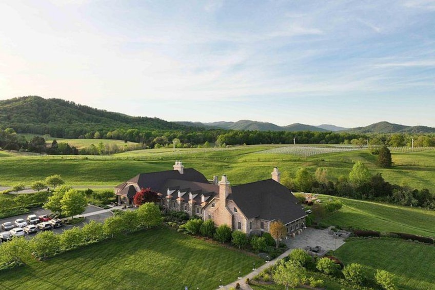 A large estate with a prominent house, expansive green fields, and rolling hills in the background. 4