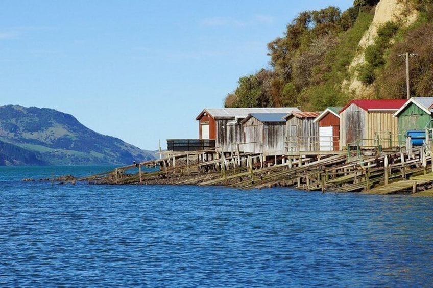 A coastal scene with wooden structures extending into the water, a clear sky, and mountains in the background. 3