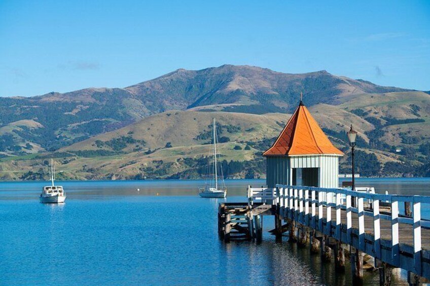 A coastal scene with a pier, boats, and a mountainous backdrop. 4