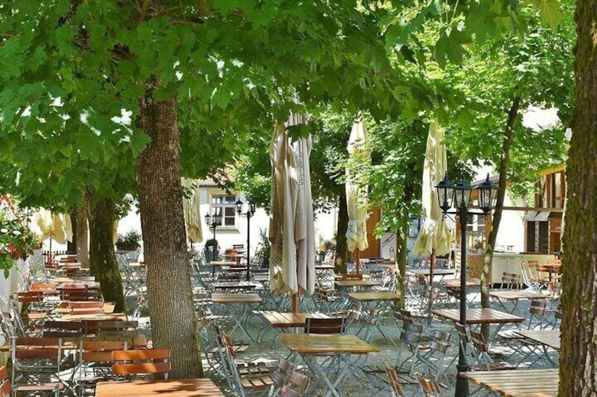 Outdoor seating with umbrellas and trees. 2