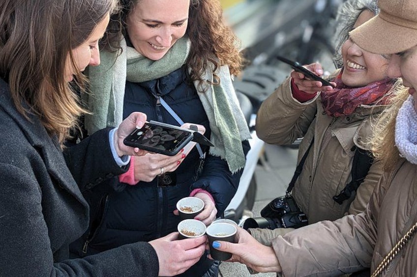 Three people holding cups and a smartphone. 5