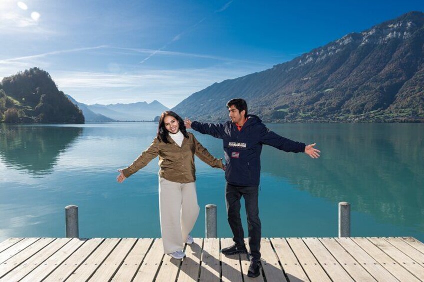 A wooden dock extending into a calm lake with mountains in the background. 4
