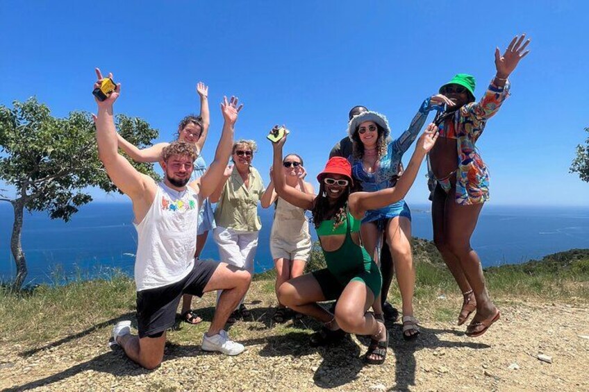 A group of people posing on a hill with a view of the ocean. 3