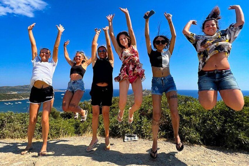 A group of people jumping in the air with a coastal landscape in the background. 2
