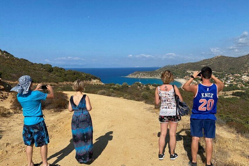 Four people standing on a dirt path with a coastal view. 2