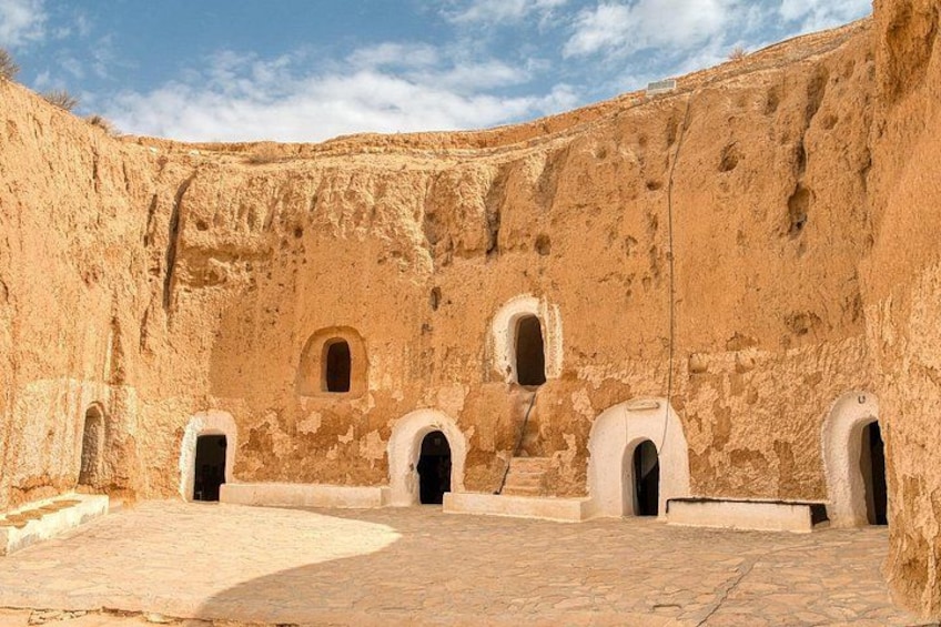 An ancient ruin with arched doorways and a courtyard. 3