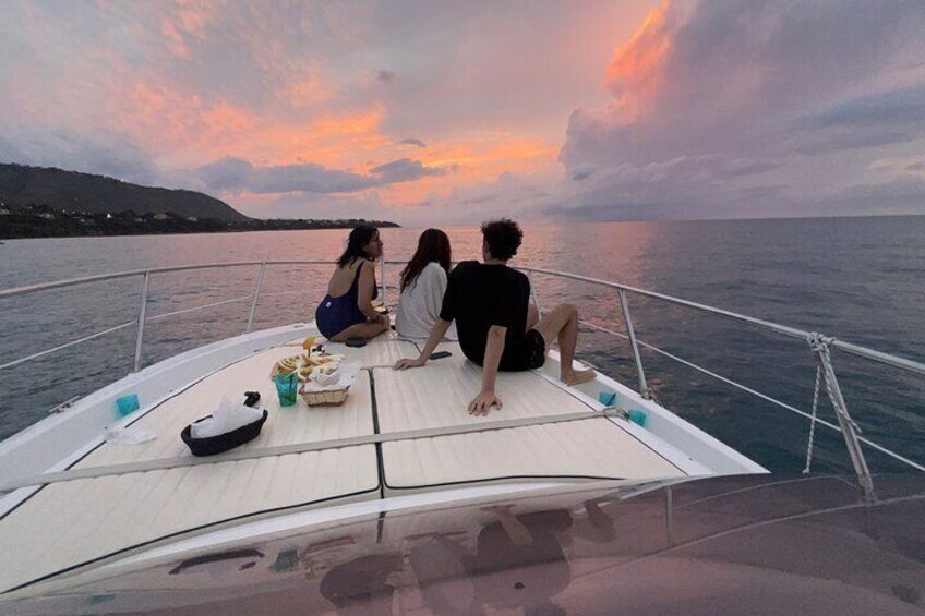 Three people on a boat with a sunset in the background. 3
