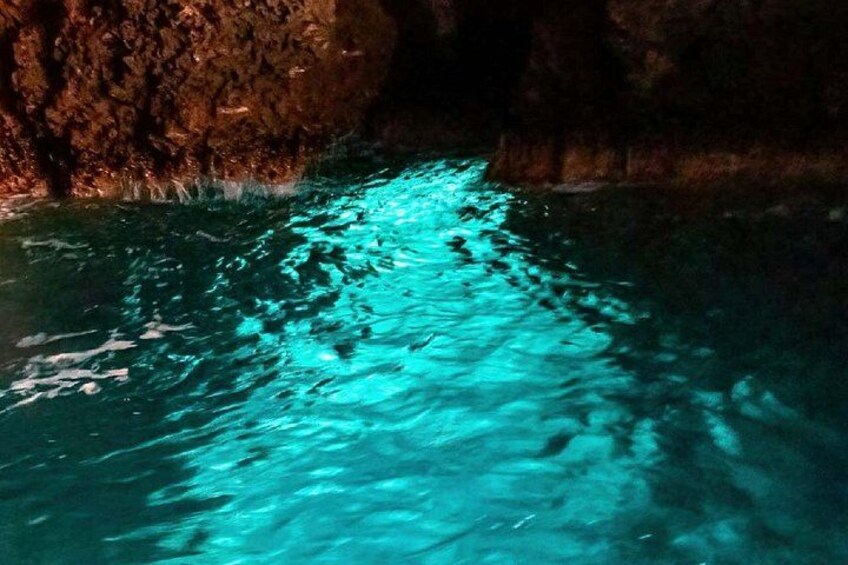 Una grotta con acque turchesi che riflettono la luce. 5