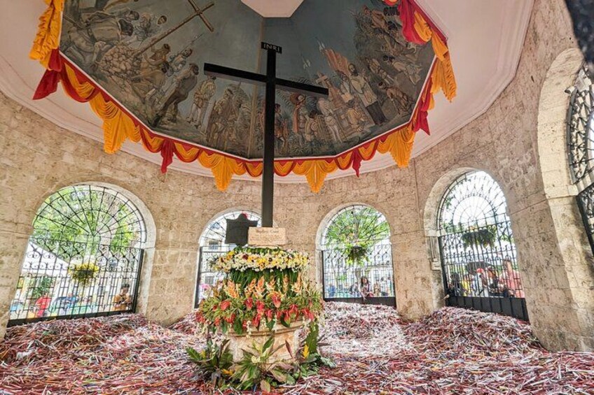 A church interior with a cross, altar, and stained glass windows. 3