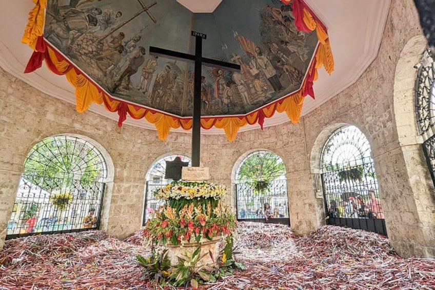 A church interior with a cross, altar, and stained glass windows. 2