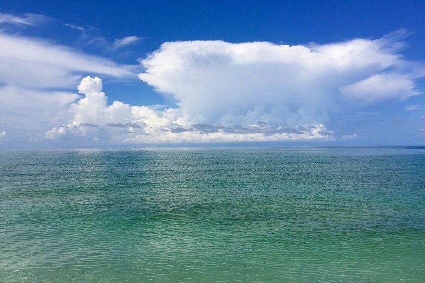 Une mer calme, un ciel dégagé et une vaste formation nuageuse. 3