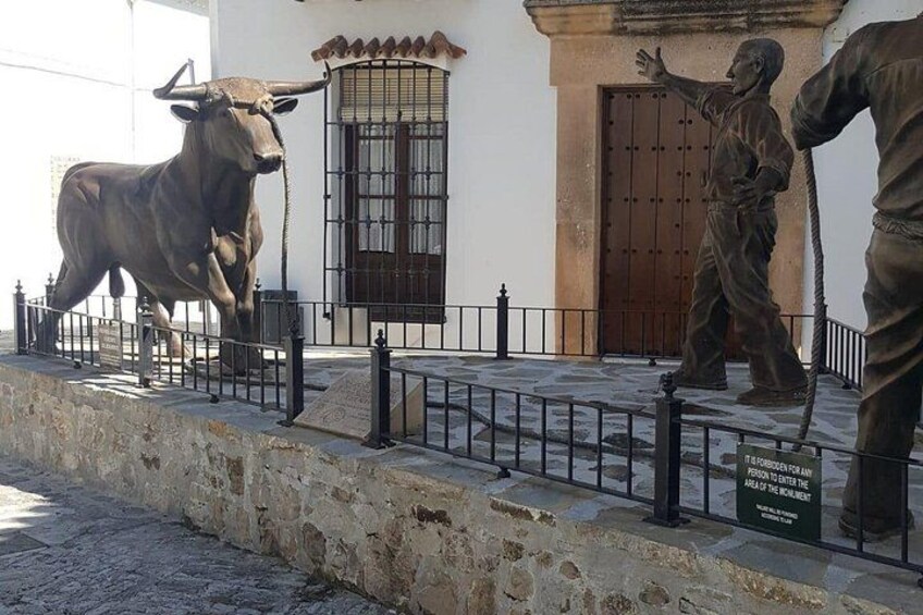 A bull statue, a man statue, and a building with a barred door. 2