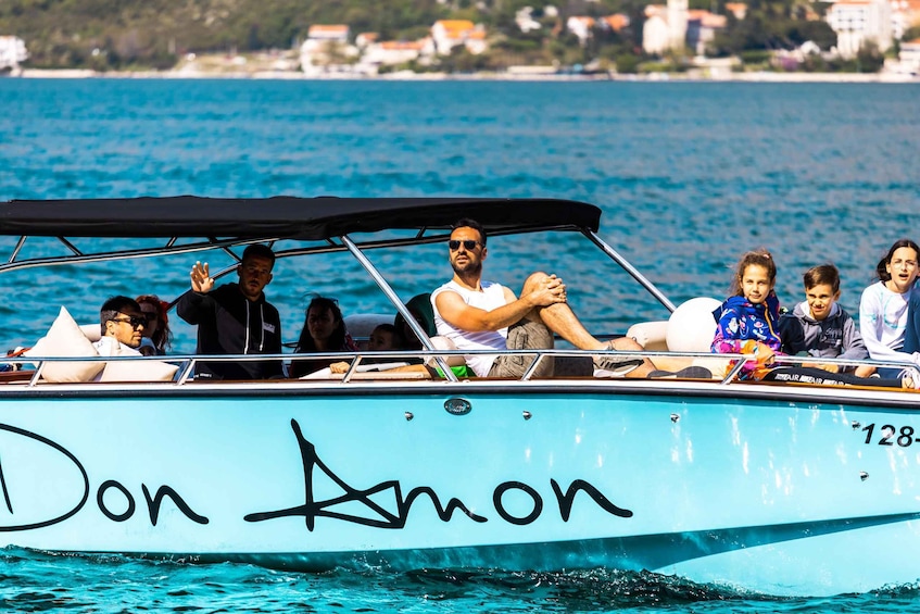 A boat named 'Don Anon' with people on board. 1