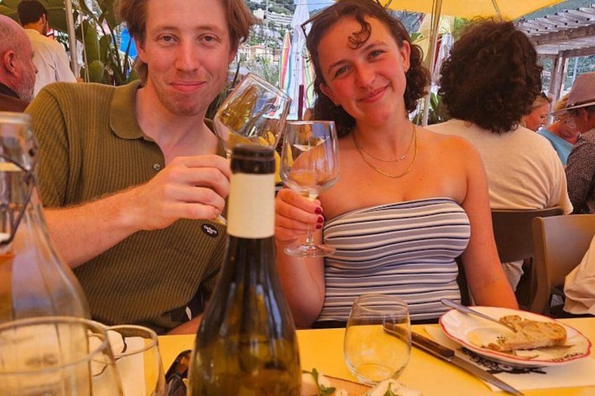 Deux personnes sont assises à une table devant une bouteille de vin et un verre. 2
