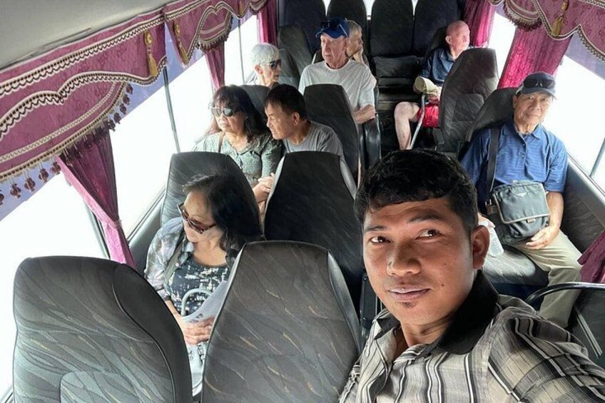 A bus interior with passengers seated. 5