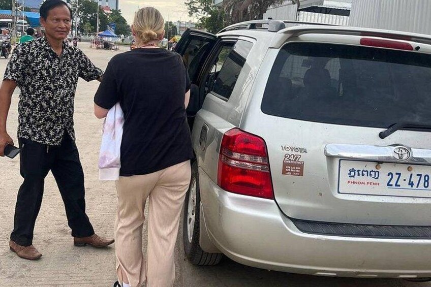 A silver Toyota Montero parked with its rear door open, a license plate visible, and a person standing beside it. 1