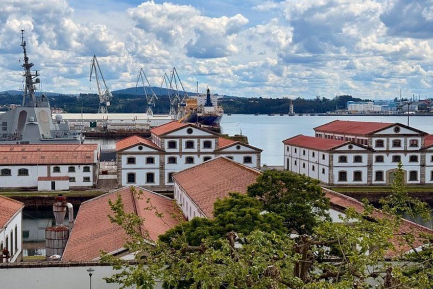A coastal town with white buildings, a ship, and cranes in the background. 3